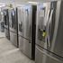 Rows of premium stainless steel refrigerators at Appliances 4 Less showroom